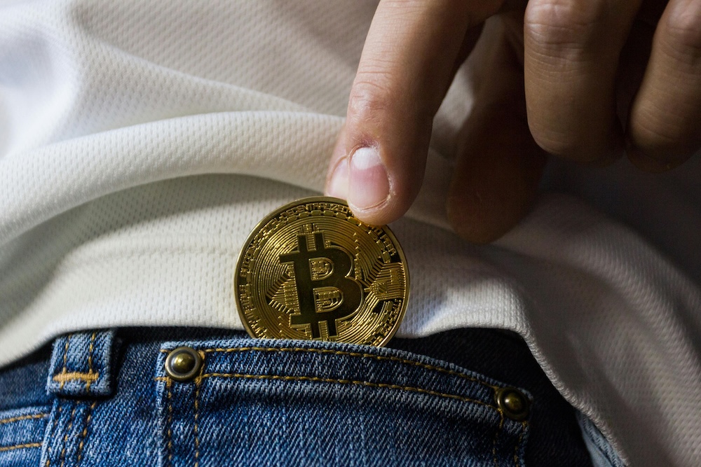 Person holding Bitcoin coin